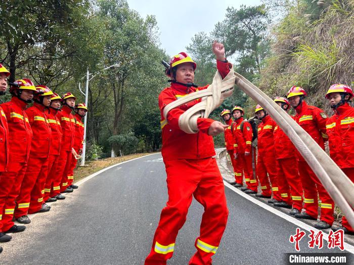 钟晓金正在向队员们展示如何快速回收消防水带。 杜南音 摄 钟晓金正在向队员们展示如何快速回收消防水带。 杜南音 摄